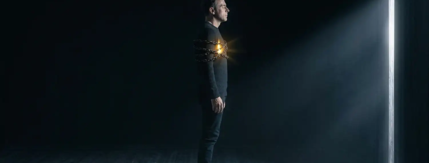l'uomo fermo, bloccato, con l'entusiasmo nel cuore compresso dalla catena della paura, doppia ombra, di ciò che è suo che non si è permesso e di ciò che lo insegue